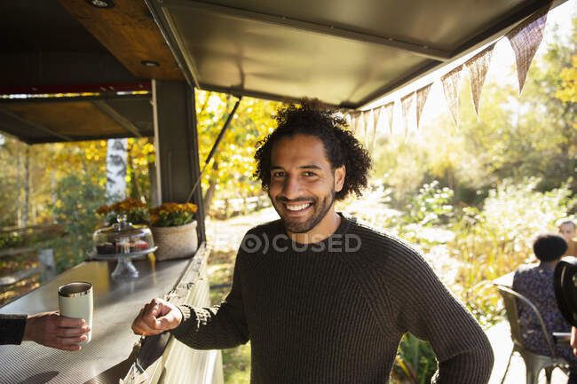 Портрет щасливий чоловік клієнт замовляє каву в продовольчому візку в парку — стокове фото