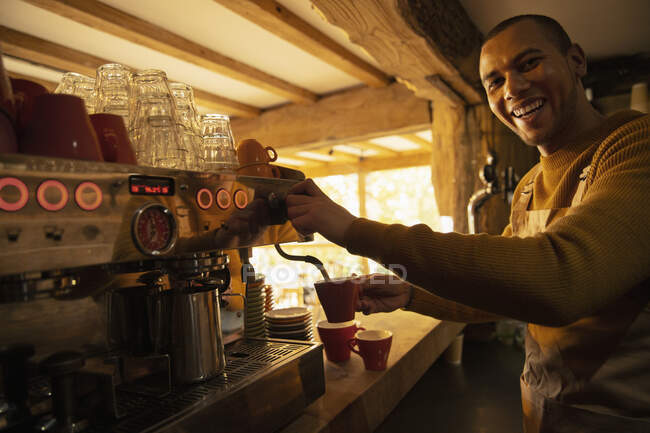 Retrato feliz barista masculino preparando café en la cafetera espresso - foto de stock