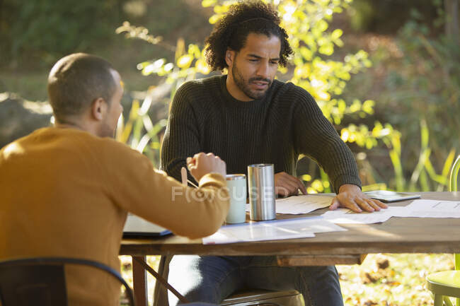 Geschäftsleute besprechen Papierkram am Tisch im Park — Stockfoto