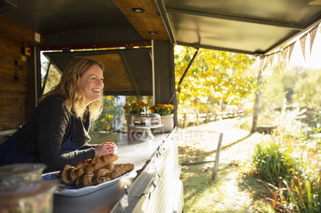 Carrinho de comida feminina feliz proprietário no ensolarado parque de outono — Fotografia de Stock