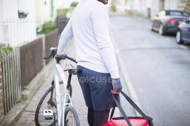 Messaggero bici maschile consegna cibo sulla strada urbana — Foto stock