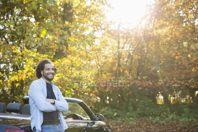Glücklicher Mann beim Cabrio im sonnigen Herbstpark — Stockfoto