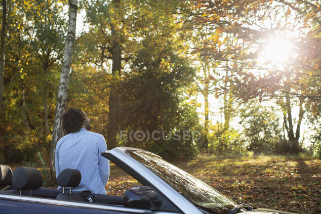 Mann im Cabrio in sonnigem Herbstpark — Stockfoto