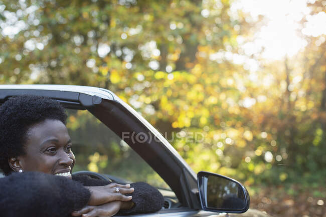 Mujer feliz en convertible en el parque de otoño - foto de stock