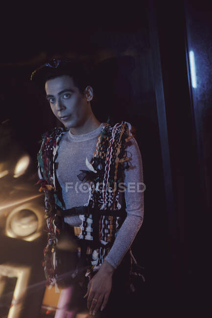 Portrait fashionable young man in chains in nightclub — Stock Photo