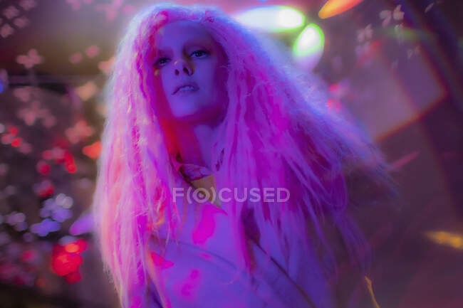 Портрет уверенной женщины с розовыми волосами в ночном клубе — стоковое фото