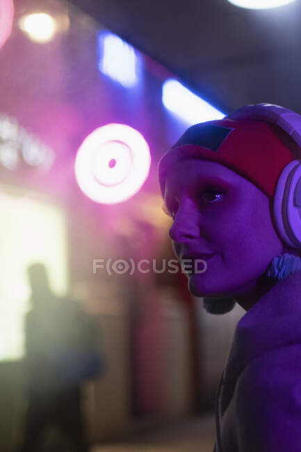 Woman with headphones in neon light — Stock Photo