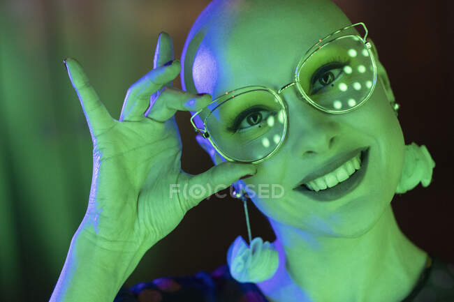 Close up portrait happy woman with retro eyeglasses in green light — Stock Photo