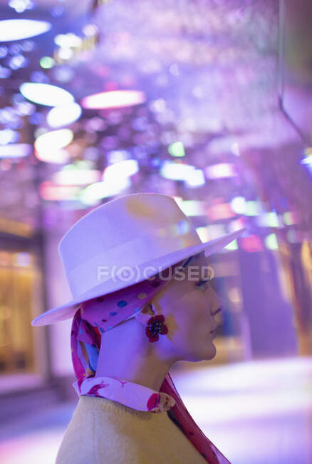 Femme à la mode en fedora sous les néons — Photo de stock