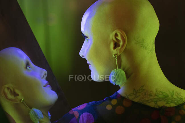 Réflexion femme élégante avec tête rasée et tatouages — Photo de stock