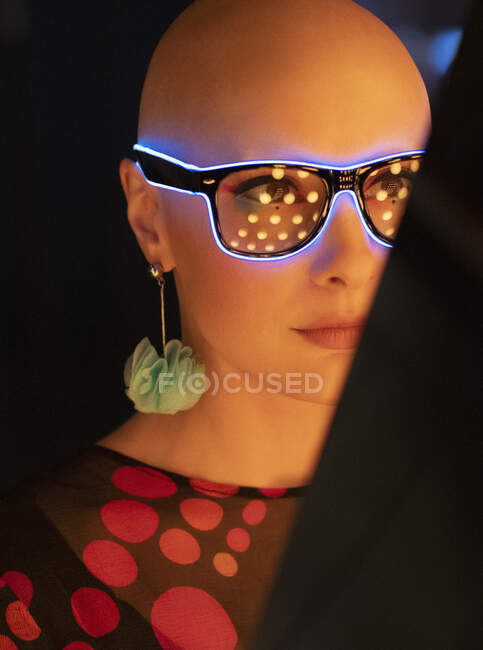 Close up ritratto donna elegante con la testa rasata in occhiali al neon — Foto stock