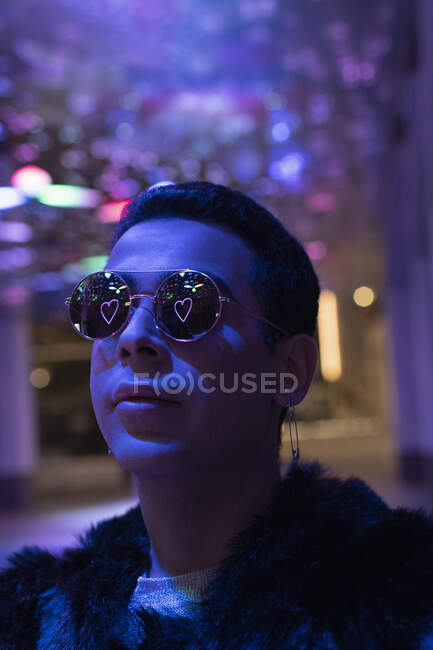 Reflection of neon heart in sunglasses of young man in city at night — Stock Photo