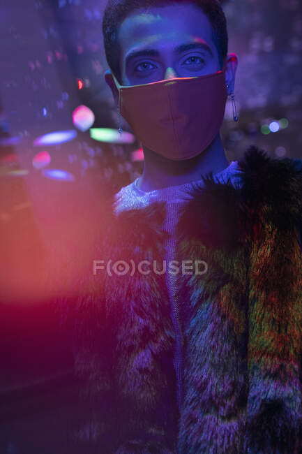 Portrait stylish young man wearing face mask in nightclub — Stock Photo