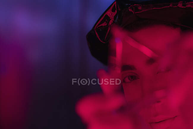 Close up portrait young man holding triangle in red light — Stock Photo