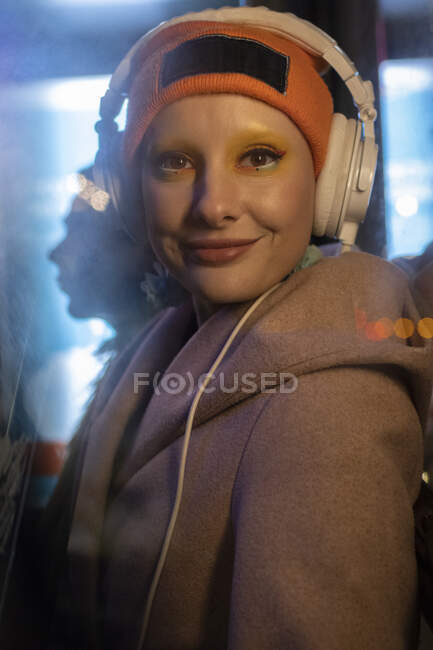 Portrait happy stylish woman with headphones and stocking cap — Stock Photo