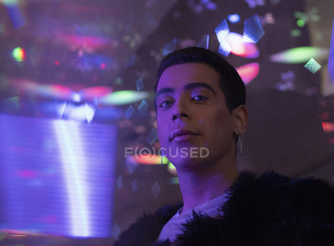 Портрет стильный молодой человек под неоновыми огнями в ночном клубе — стоковое фото