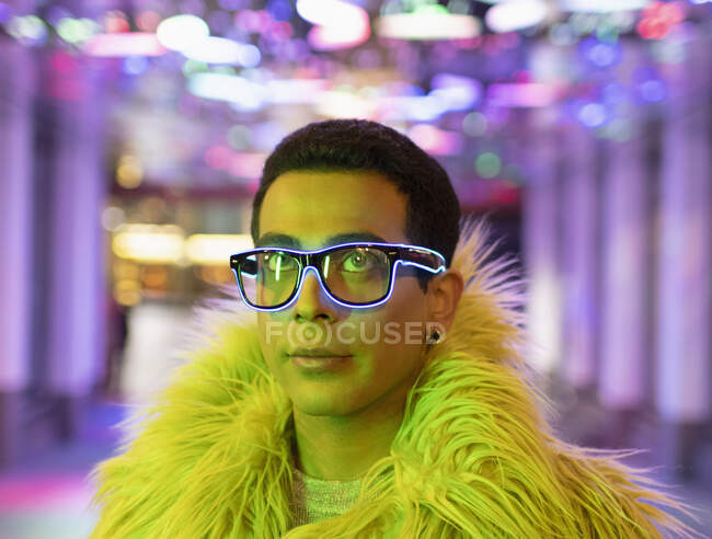 Portrait stylish young man in feather boa and neon eyeglasses — Stock Photo