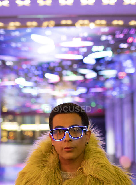 Portrait élégant jeune homme en plumes boa et néon lunettes — Photo de stock