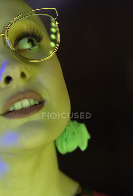 Close up beautiful stylish woman in retro eyeglasses in green light — Stock Photo