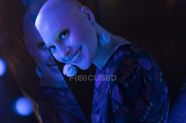 Porträt schöne Frau mit rasiertem Kopf in blauem Neonlicht — Stockfoto