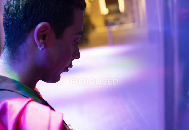 Jeune homme regardant en bas dans l'éclairage au néon — Photo de stock