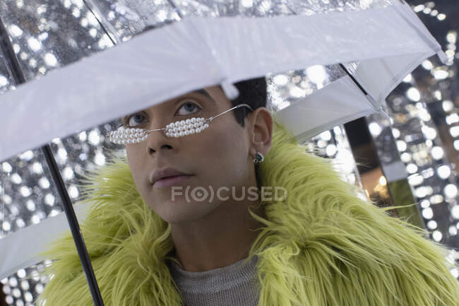 Portrait jeune homme à la mode en plumes boa sous parapluie — Photo de stock