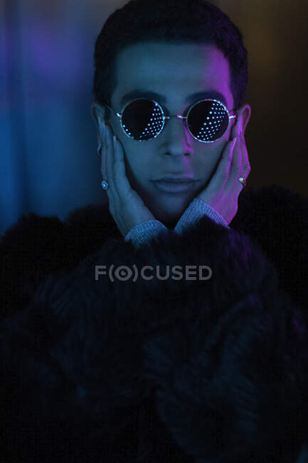 Portrait cool stylish young man wearing sunglasses in dark — Stock Photo