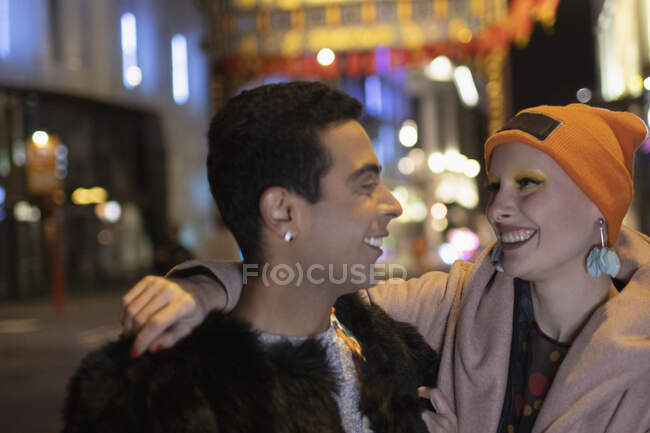 Happy stylish couple on city street at night — Stock Photo