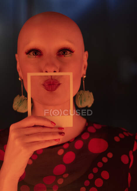 Retrato hermosa mujer con estilo con la cabeza afeitada celebración polaroid - foto de stock