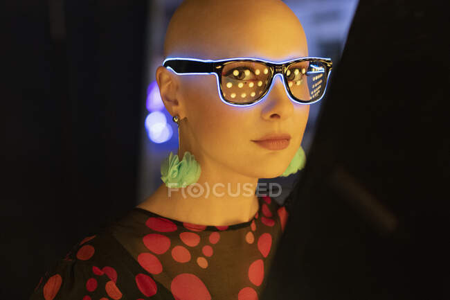 Retrato mujer con estilo en gafas de neón y pendientes - foto de stock