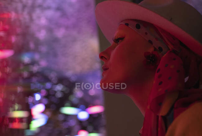 Stylish woman in fedora in dark nightclub — Stock Photo