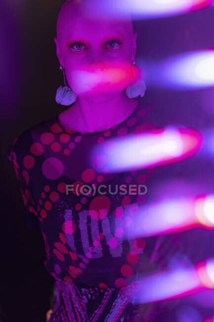 Portrait stylish woman with shaved head in neon light — Stock Photo
