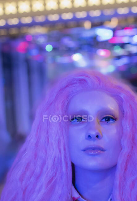 Portrait confident cool woman with pink hair under neon light — Stock Photo