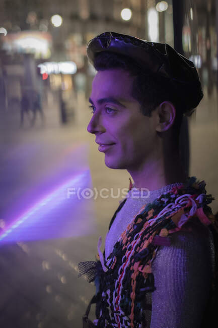Eccentric young man on city sidewalk at night — Stock Photo