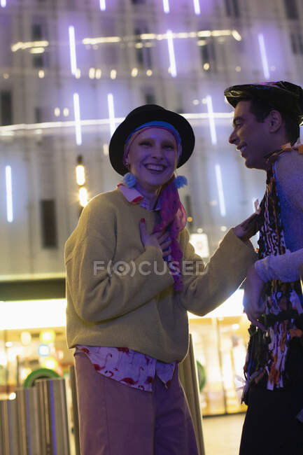 Portrait happy stylish young couple below modern building at night — Stock Photo