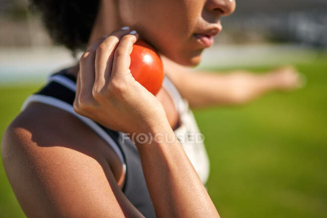 Close up female track and field athlete preparing to throw shot put — Stock Photo