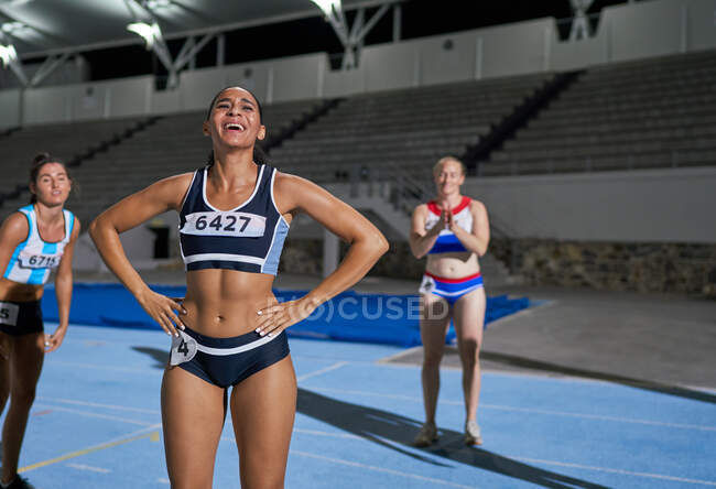Tired female track and field athletes in stadium — Stock Photo