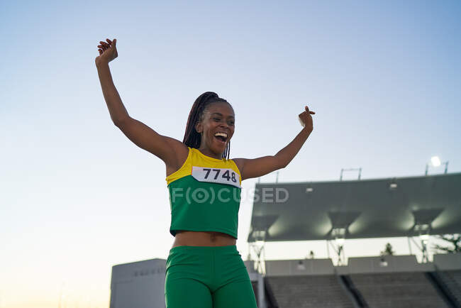 Щаслива жінка-трек і польовий спортсмен святкує на змаганнях — стокове фото