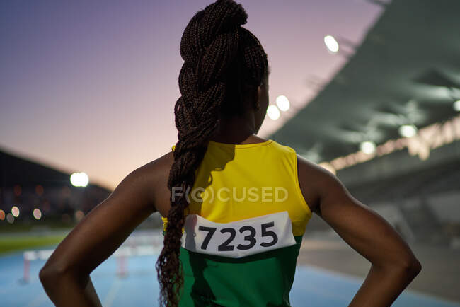 Female track and field athlete with long black braids in stadium — Stock Photo
