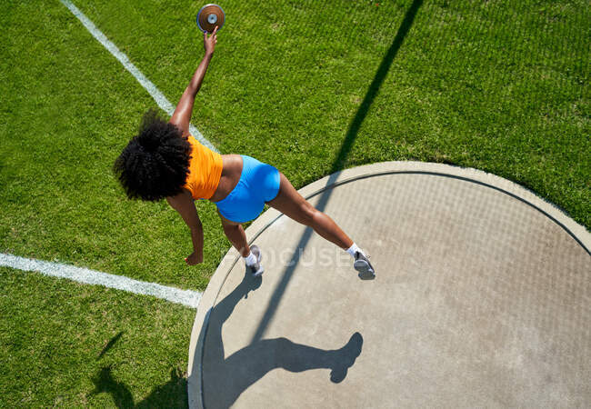 Female track and field athlete throwing discus — Stock Photo
