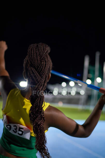 Athlète féminine d'athlétisme avec des tresses noires jetant le javelot — Photo de stock