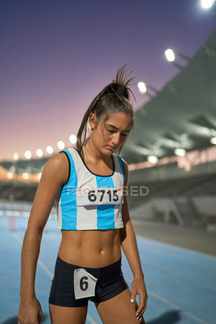 Tired female track and field athlete on track after competition — Stock Photo