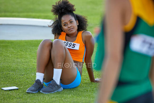 Atletismo feminino e atleta de campo descansando na grama — Fotografia de Stock