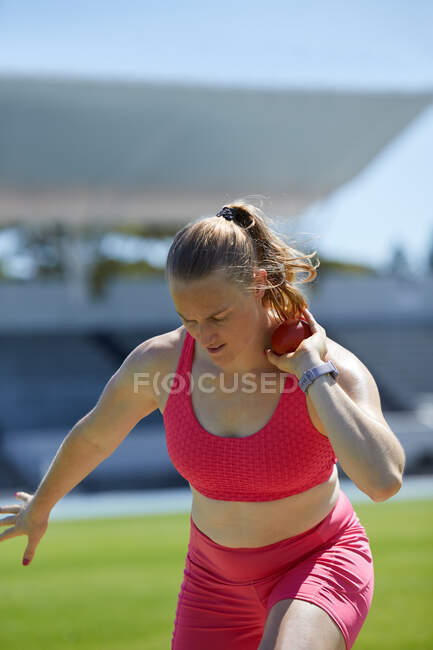 Female track and field athlete throwing shot put — Stock Photo