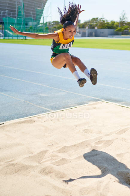Female track and field athlete long jumping — Stock Photo