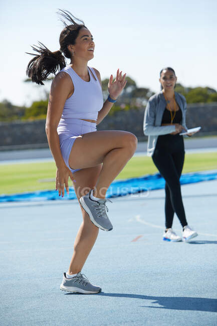Atletismo feminino e atleta de campo aquecendo na pista — Fotografia de Stock