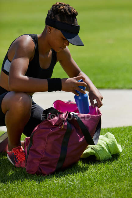 Leichtathletin mit Wasserflasche und Tasche — Stockfoto