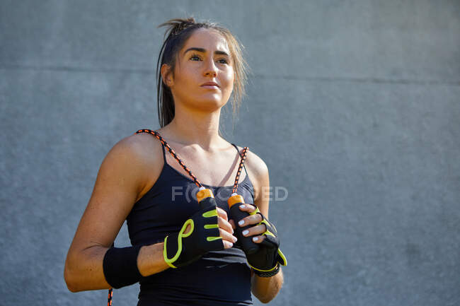 Porträt selbstbewusste Sportlerin mit Springseil — Stockfoto