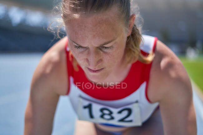 Close up focused female track and field athlete preparing for race — Stock Photo