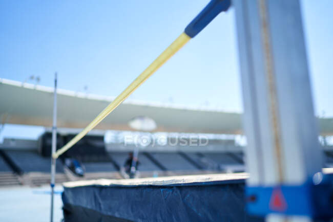 High jump pole and padding in sunny stadium — Stock Photo